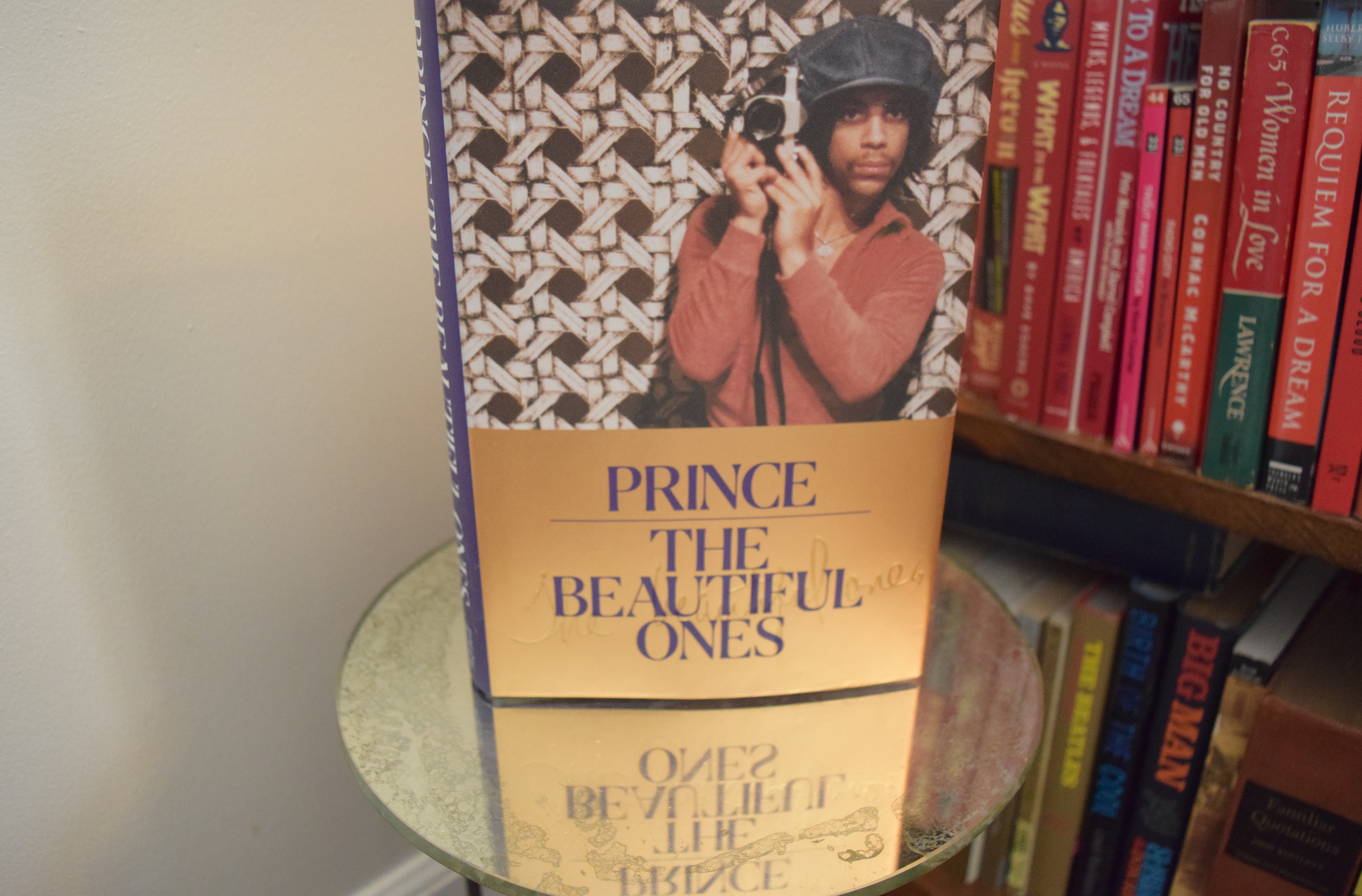 Prince: The Beautiful Ones, on a shelf of books